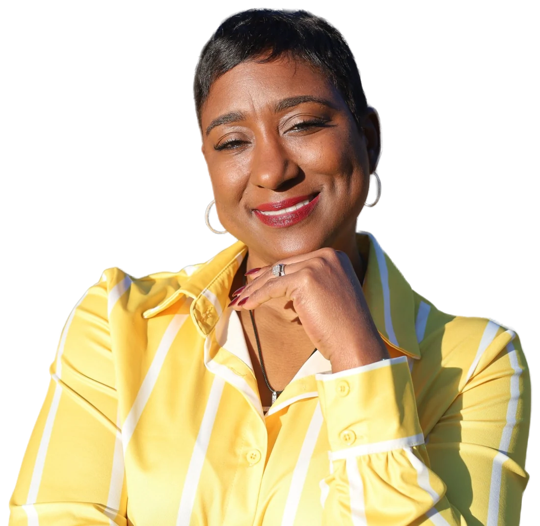 Karyn “KG” Gordon, founder of Blowouts & Brunch, smiling with her chin on her hand in a yellow striped blouse